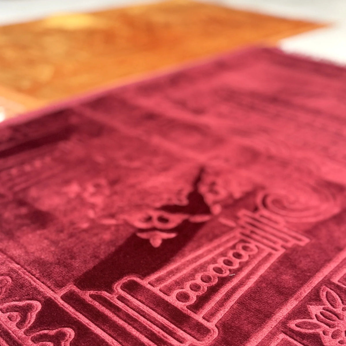 Detailed texture of maroon prayer mat from Golden & Maroon Couple Janamaz Set, highlighting plush fabric and elegant Islamic design.