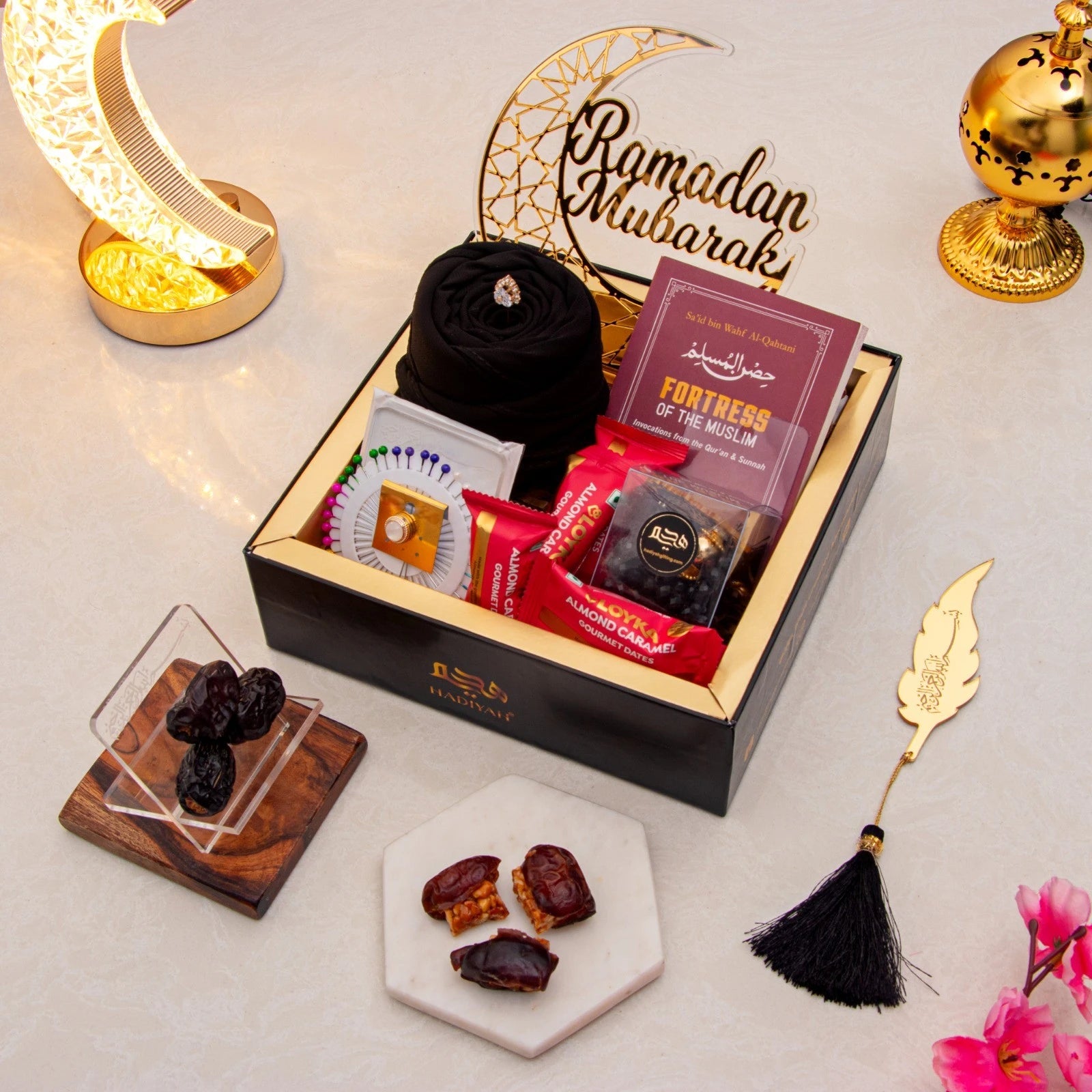 Golden Ramadan Mubarak Hamper - Ramadan Gift Hamper with black hijab, Islamic book, dates, sweets, and decorative crescent moon. Main image
