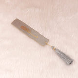 Grey and gold Islamic bookmark with tassel, part of the Grey Stones Quran Gift Hamper. Complements the premium Quran set.