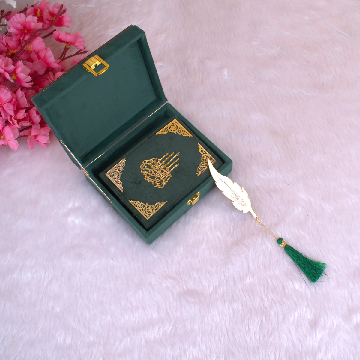 Mini Tilawat-e-Quran with gold feather bookmark placed inside an open green velvet box with intricate gold detailing and tassel accent.