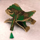 Decorative item with green and gold colors on a white background