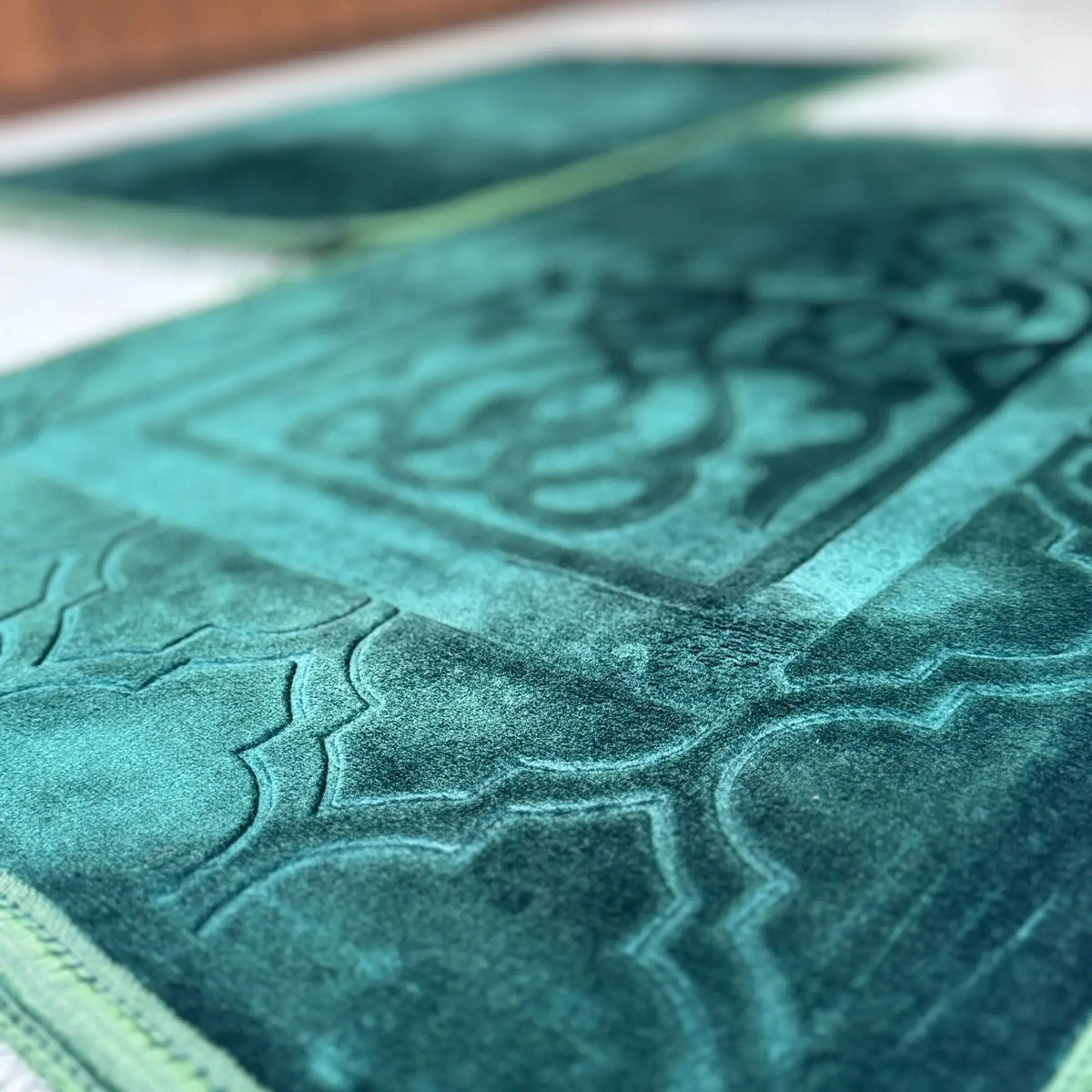 Couple Janamaz with Heart in rich green velvet, featuring intricate embossed patterns. Premium prayer mats ideal for Islamic wedding gifts.
