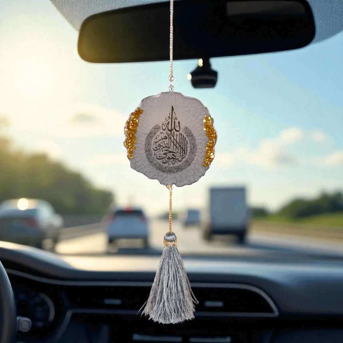 Grey Flakes Designer Car Hanging - 3 inches with shimmering flake pattern and tassel, hanging from rear view mirror on a highway drive.