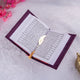 Open Quran with black and white Urdu translation and gold feather bookmark. Included in the Purple Quran Hamper Set for diverse readers.