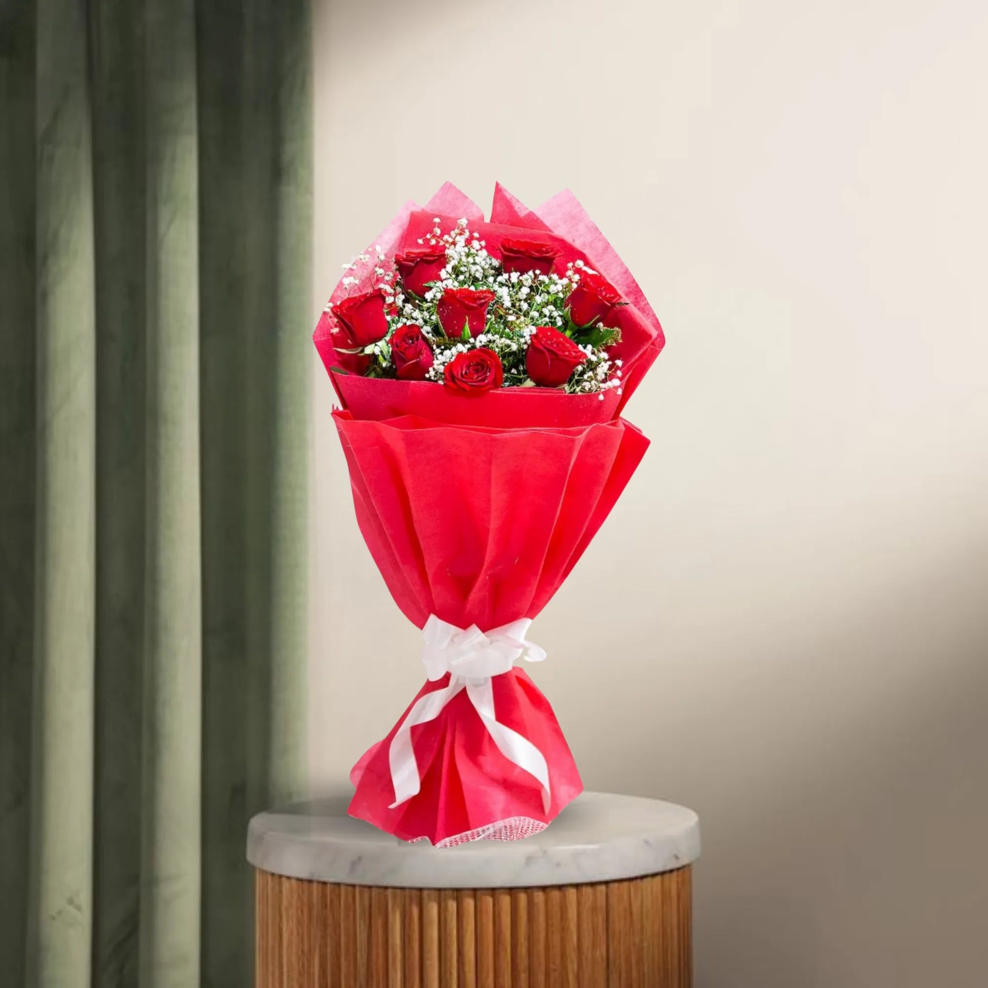 8 Red Roses Bouquet wrapped in red paper with white ribbon, displayed on a marble-top table. Romantic gift for anniversaries or Valentine's Day.
