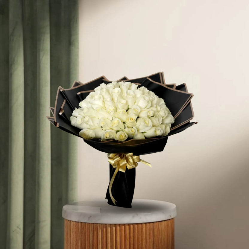 Peaceful White Roses Bouquet - White Roses | 100 Stems arranged with green fillers in black paper wrapping, ideal for condolences or celebrations. Main image