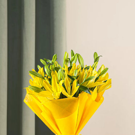 Close-up of Asiatic Lilies Bunch - Lovely Flowers with fresh yellow buds and green leaves, elegantly wrapped for gifting or special occasions.