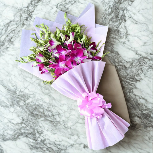 Orchids Bouquet Gift featuring fresh purple orchids in lilac wrapping with a pink bow, perfect for weddings or same day delivery surprises.