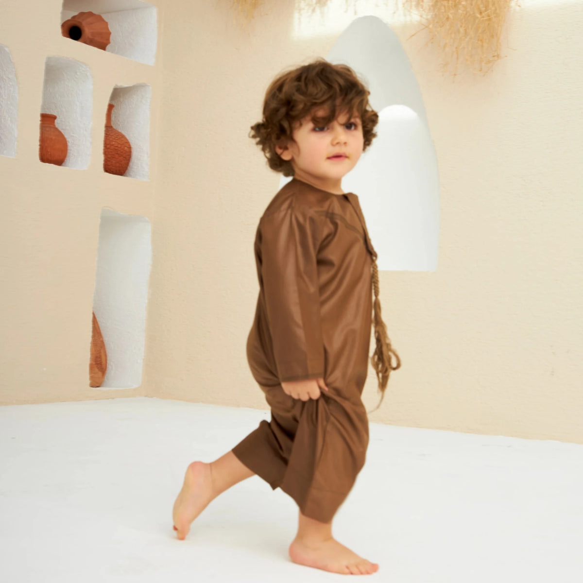 Toddler walking in Brown Thobe Romper Boys - Baby Boys Thobe Romper, ideal for festive wear with breathable material and cultural design.