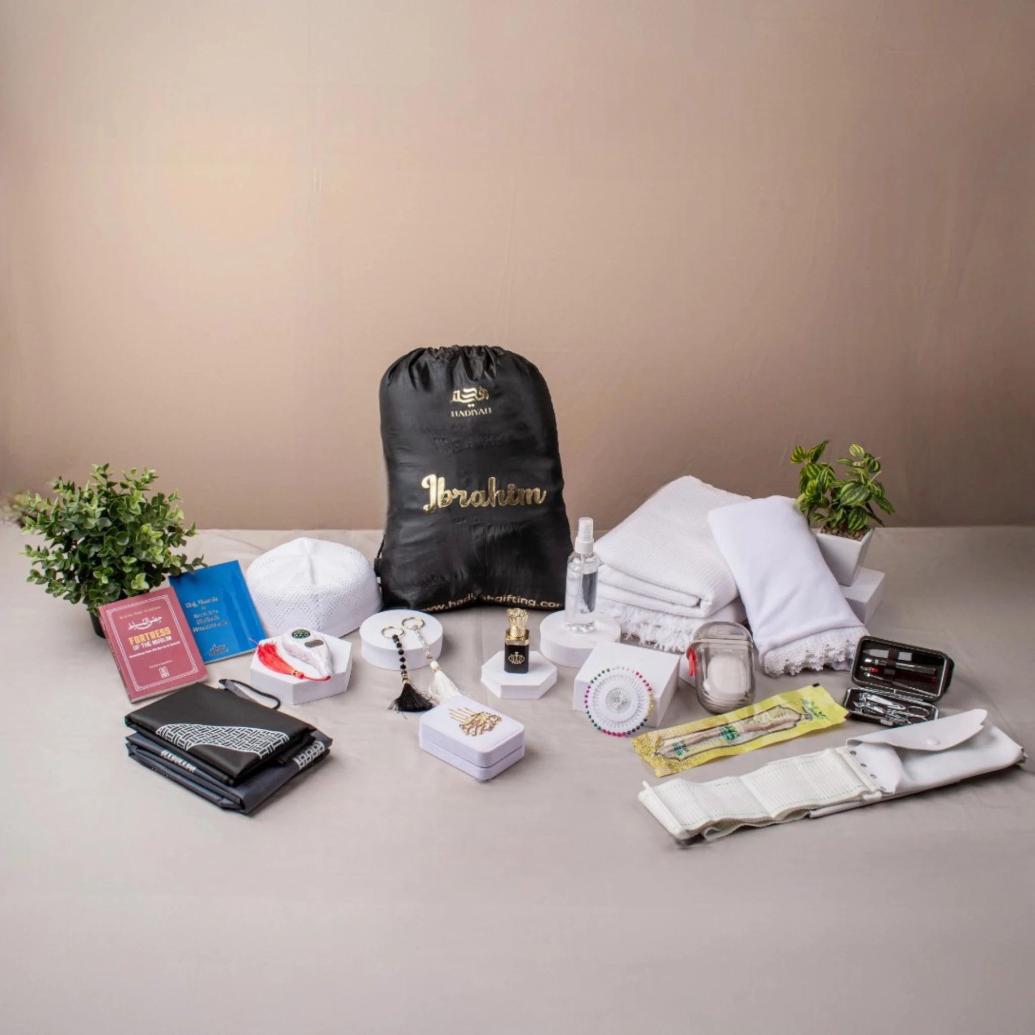 Hajj-e-Mabroor Luxe Couple Set with Ihram, hijab, prayer mat, tasbeeh, and travel accessories for a complete pilgrimage experience.