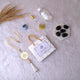 Barakah Hajj Gift Hamper Pack with tasbih, Zamzam water, Ajwa dates, and Islamic accessories on white fur background. Ideal Hajj return gift set.