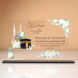 Labbaik-e-Haram Gifting Plaque featuring Kaaba and Masjid Nabawi illustrations with floral accents, ideal for Hajj or Umrah return gifts or keepsakes.