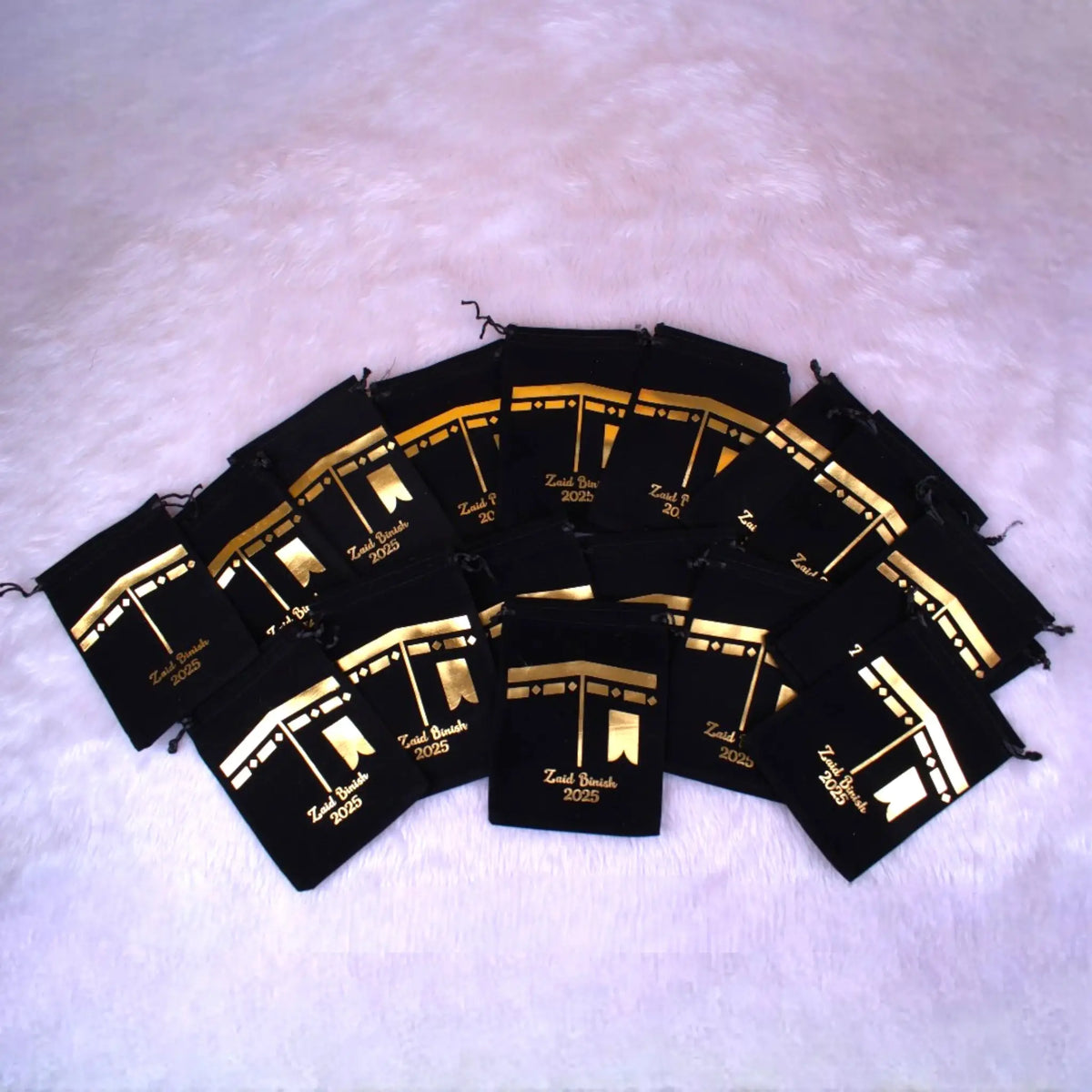 Multiple Tasleem Gift Set velvet pouches arranged in a fan shape, customized for Hajj Umrah return favours, ideal for religious gifting.