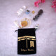 Tasleem Gift Set - Hajj Umrah Return Favours with velvet pouch, Ajwa dates, Zamzam water, attar, Tasbeeh, and chocolate on white fur background.