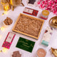Gourmet gift set with chocolates, flowers, and a card on a white surface.