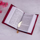 Open book with a gold feather bookmark on a light gray background