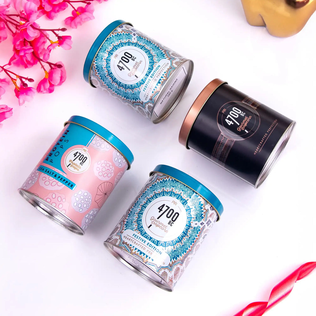 Luxury Assorted Gourmet Popcorn Hamper with four flavor tins including chocolate and sea salt, beautifully arranged for festive gift delivery.