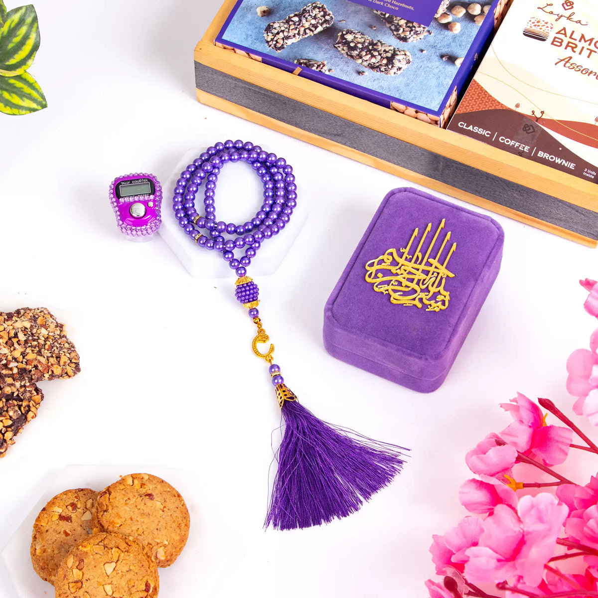 Velvet Bliss & Nut Hamper includes a purple velvet prayer box, tasbih, digital counter, and gourmet snacks, ideal for Ramadan and Eid gifting.