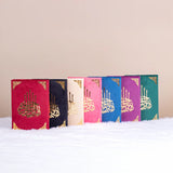 Collection of Velvet Covered Qurans in assorted colors with gold Arabic calligraphy. Premium Islamic gift set for religious ceremonies.