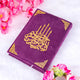 Elegant purple velvet Quran with gold detailing from the Butterfly Sawab-e-Jariya gift set, surrounded by pink flowers on white fur.
