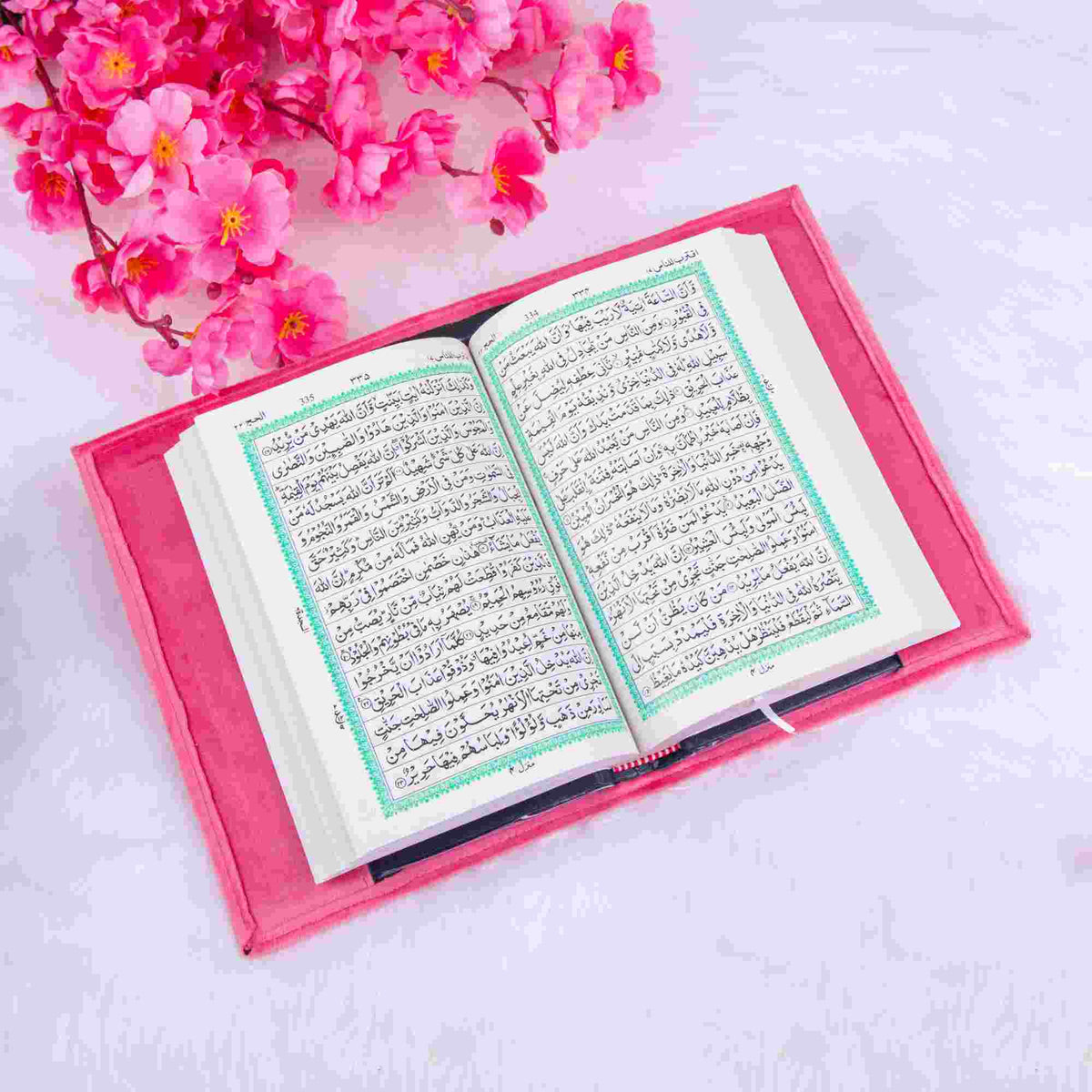 Open pink velvet Quran with Arabic script and green border. A spiritual and elegant gift from the Pink Bridal Hamper collection.