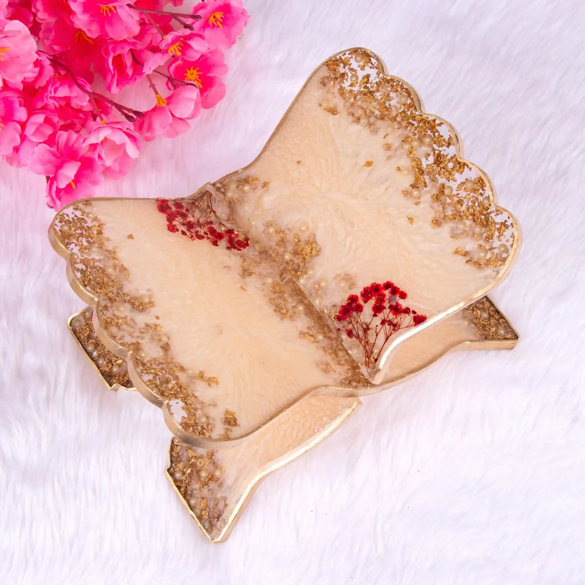 Decorative leaf-shaped tray with gold and beige finish on a white background with pink flowers. Main image