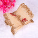Decorative leaf-shaped tray with gold and beige finish on a white background with pink flowers.