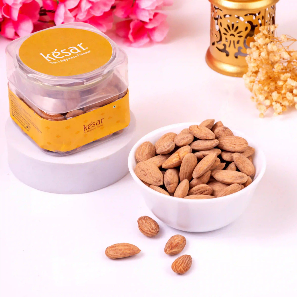 Kesar premium almonds in shell in a clear jar with a bowl of almonds beside it. Part of Noor Al-Sweets & Serenity Hamper for Ramadan gifts.