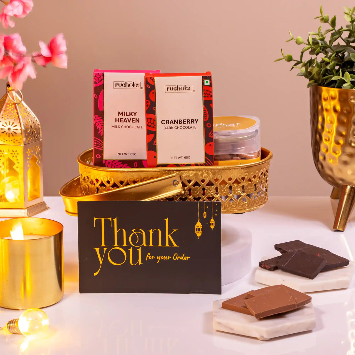 Noor Al-Nazakat Sweet Treats Hamper with premium chocolates, almonds, candle, and thank you card in a golden tray. Ideal sweet gift hamper for celebrations.