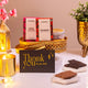 Noor Al-Nazakat Sweet Treats Hamper with premium chocolates, almonds, candle, and thank you card in a golden tray. Ideal sweet gift hamper for celebrations.
