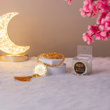 Golden Islamic tasbeeh with tassel and decorative moonlight setup, part of the Golden Sawab-e-Jariya Quran Gift Set.