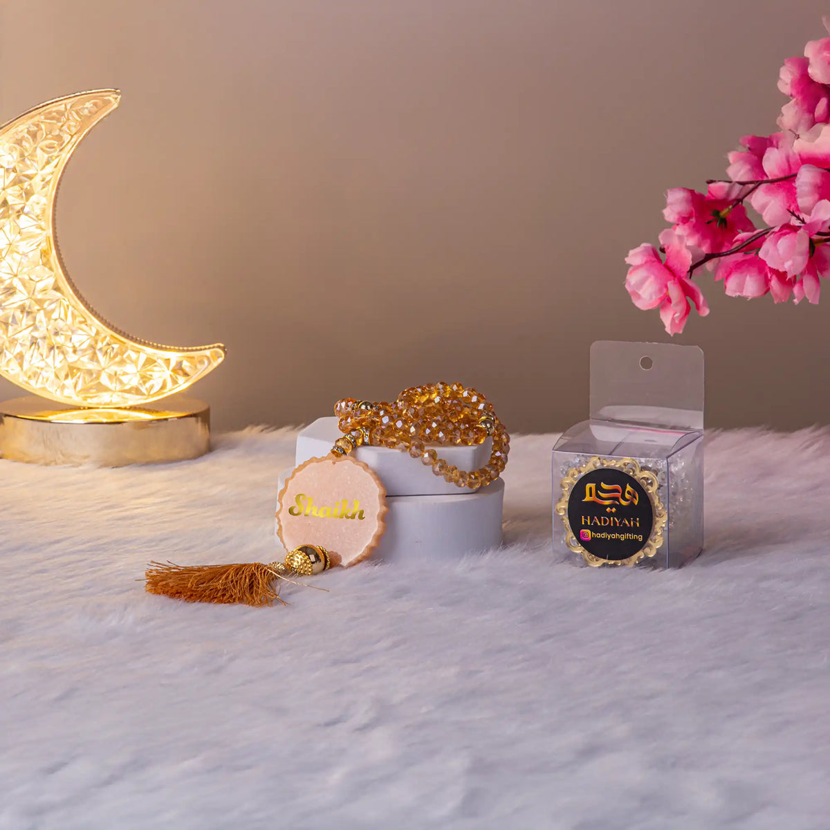 Golden crystal tasbeeh with tassel and packaging from the Golden Floral Pearl Rehal Hamper. Ideal Islamic prayer gift for Ramadan or Eid.