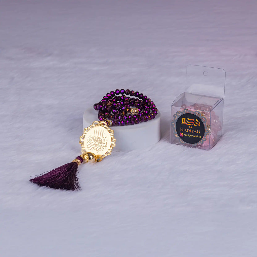 Close-up of purple beaded tasbeeh with golden medallion and tassel from the Purple Sawab-e-Jariya Gift Set. Great for spiritual gifting. Main image