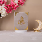 Gray Velvet Quran with gold detailing on display, premium translation Quran for gifting or religious use.