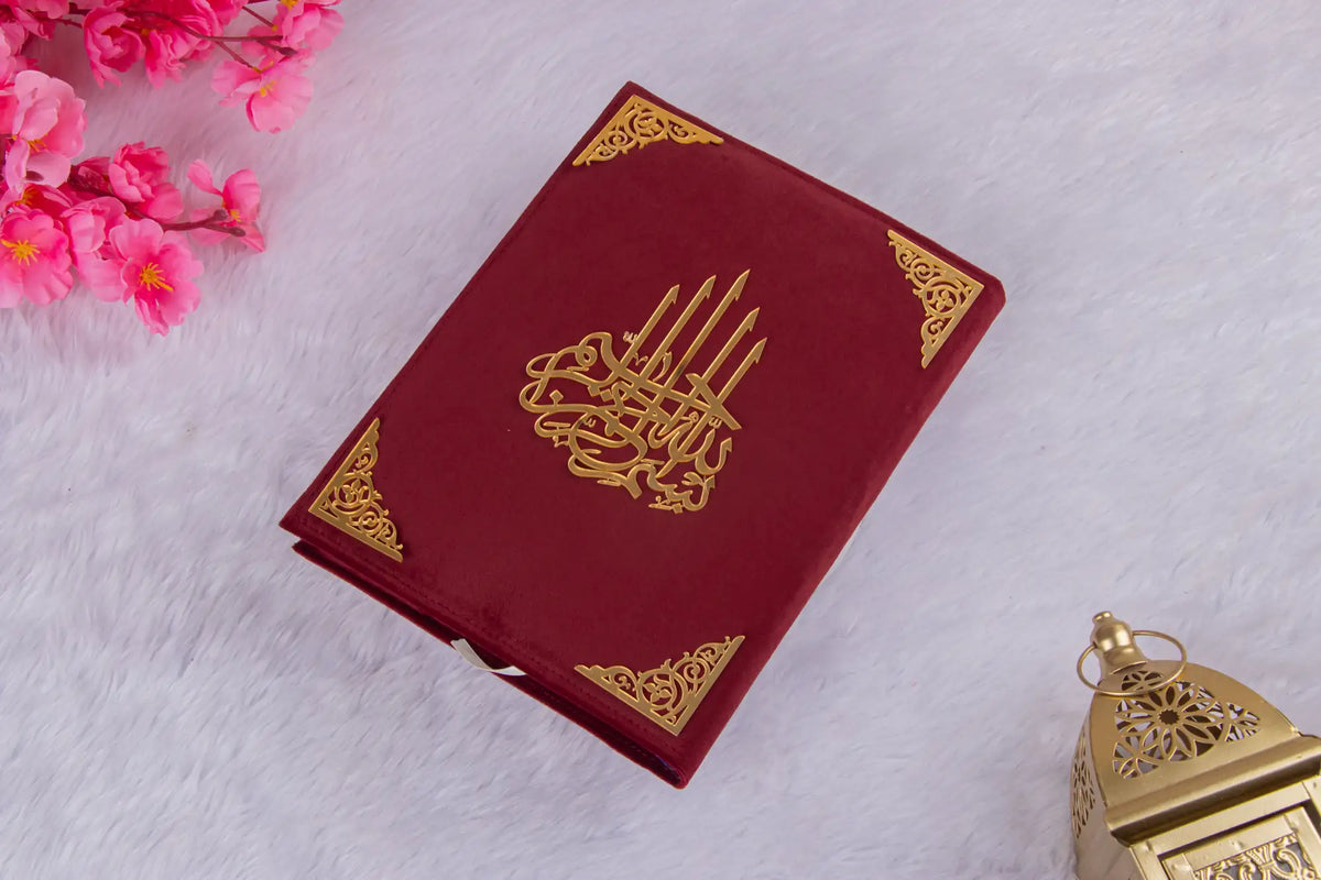 Flat-lay of maroon velvet Quran with intricate gold detailing from Amaanat-e-Nikaah Sawab-e-Jariya wedding gift set.