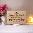 Closed beige velvet Nikah Nama Hamper box with gold foil couple's names, part of the Divine Elegance wedding collection.