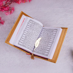 Golden Velvet Quran Translation with Hindi script, open on soft white surface with floral decor. Perfect for Ramadan and ceremonial gifting.
