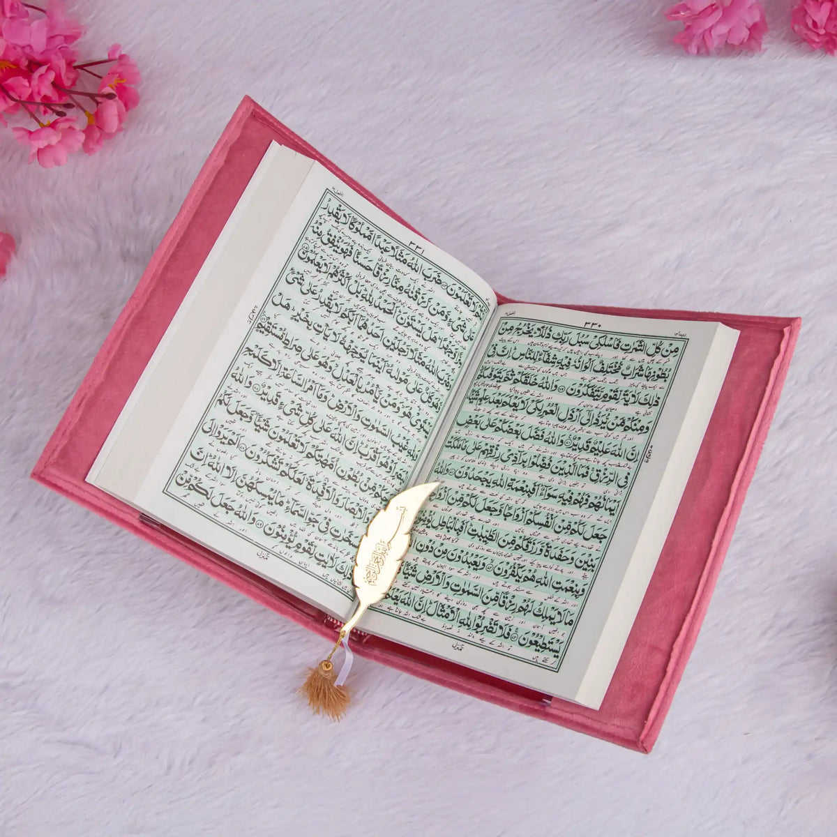 Open book with Arabic text on a pink floral background