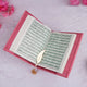 Open book with Arabic text on a pink floral background