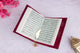 Open Velvet Quran displaying Arabic script, a sacred and beautifully bound prayer essential for daily recitation.