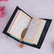 Color-coded Tajweed Quran with golden feather bookmark from the Black Sequence Bridal Sawab-e-Jariya Hamper, ideal for spiritual gifting.
