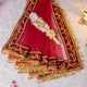 Decorative red fabric with gold embroidery and tassels on a white background