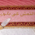 Decorative pink fabric with gold and red embroidery on a white background