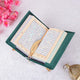 Multicolor Quran page with translation and gold feather bookmark from Green Salah Combo Hamper, styled with lantern and flowers.