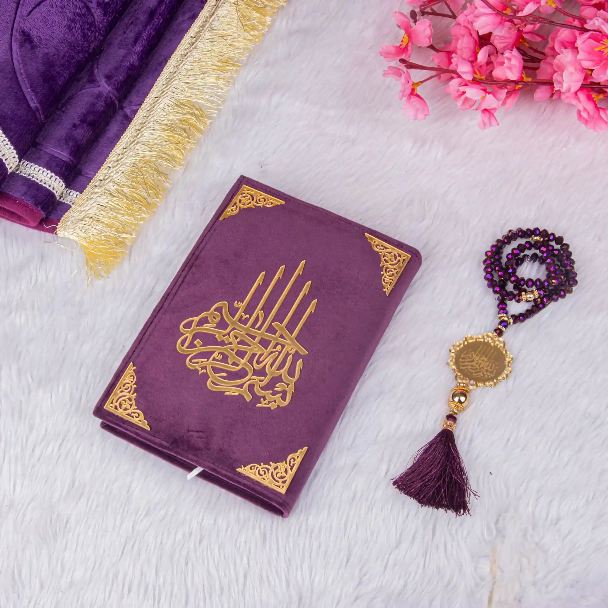Customised Purple Salah Combo Hamper featuring a velvet Quran, crystal tasbeeh, and janamaz on a white fur background with pink flowers. Main image