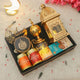 Gift set with gold lantern, 'Peri Peri Cashews' cans, and decorative items on a light background.
