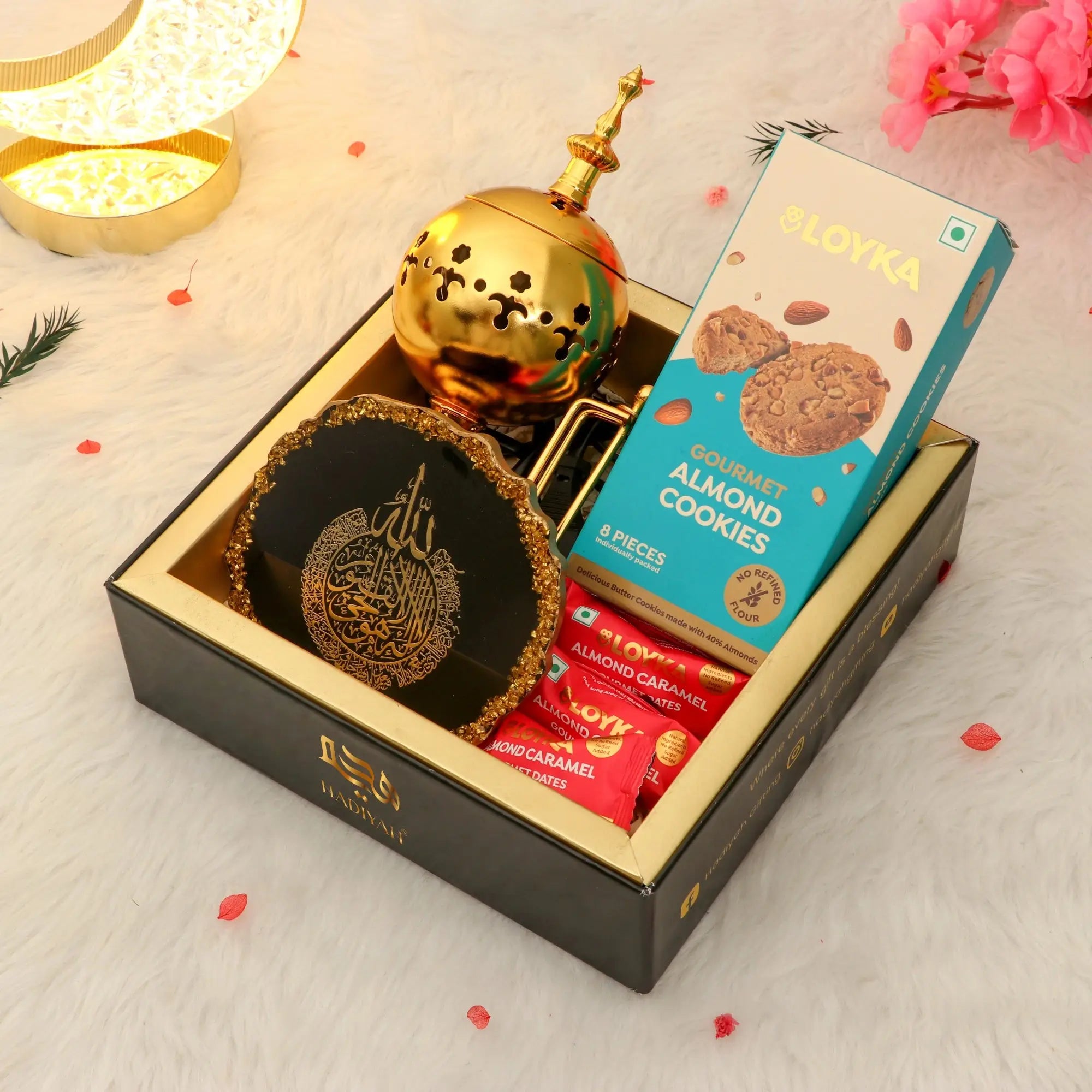 Jannah Eid Hamper - Celebrate Eid with Premium Gifts featuring black Ayatul Kursi frame, golden Bakhoor burner, almond cookies, and treats in a luxury gift box. Main image