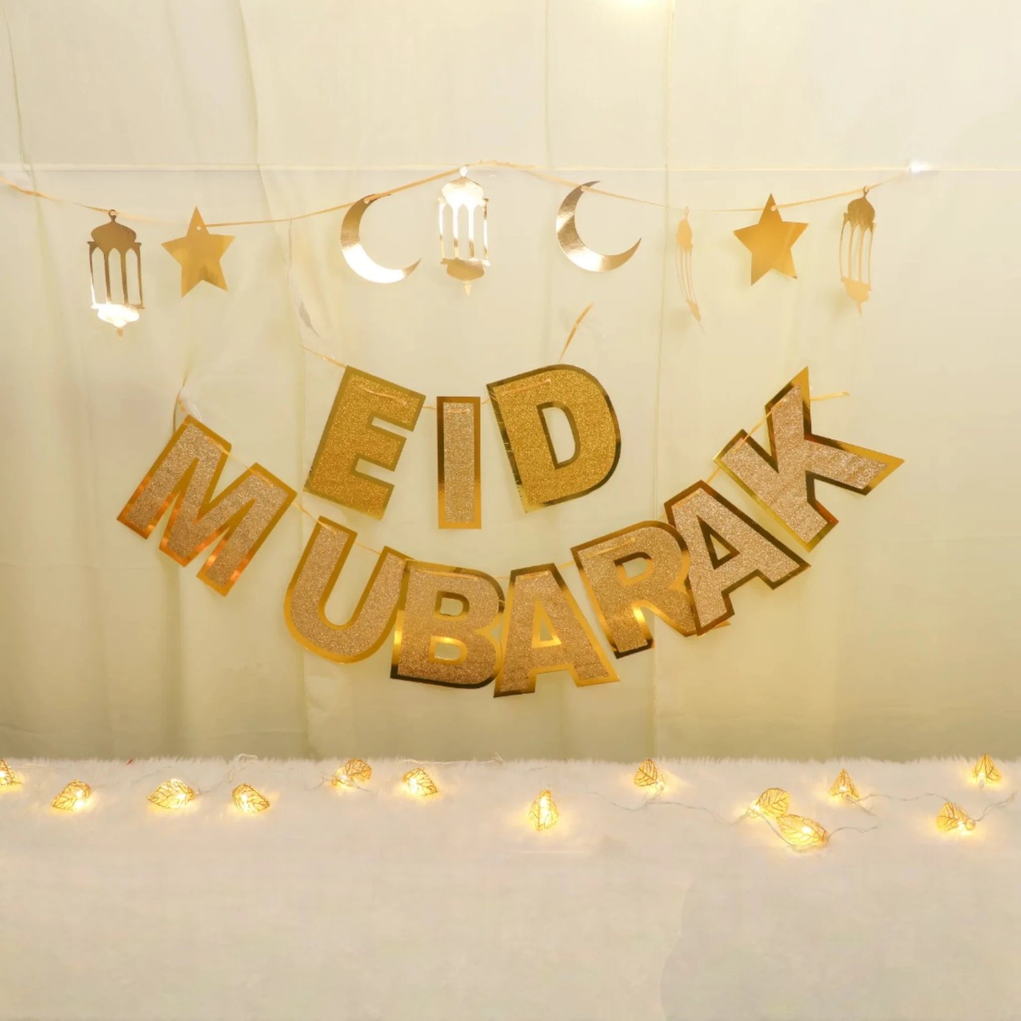 Starry Eid Delight Decor Set with gold 'Eid Mubarak' banner, moon and star garland, and warm fairy lights for festive home decoration. Main image