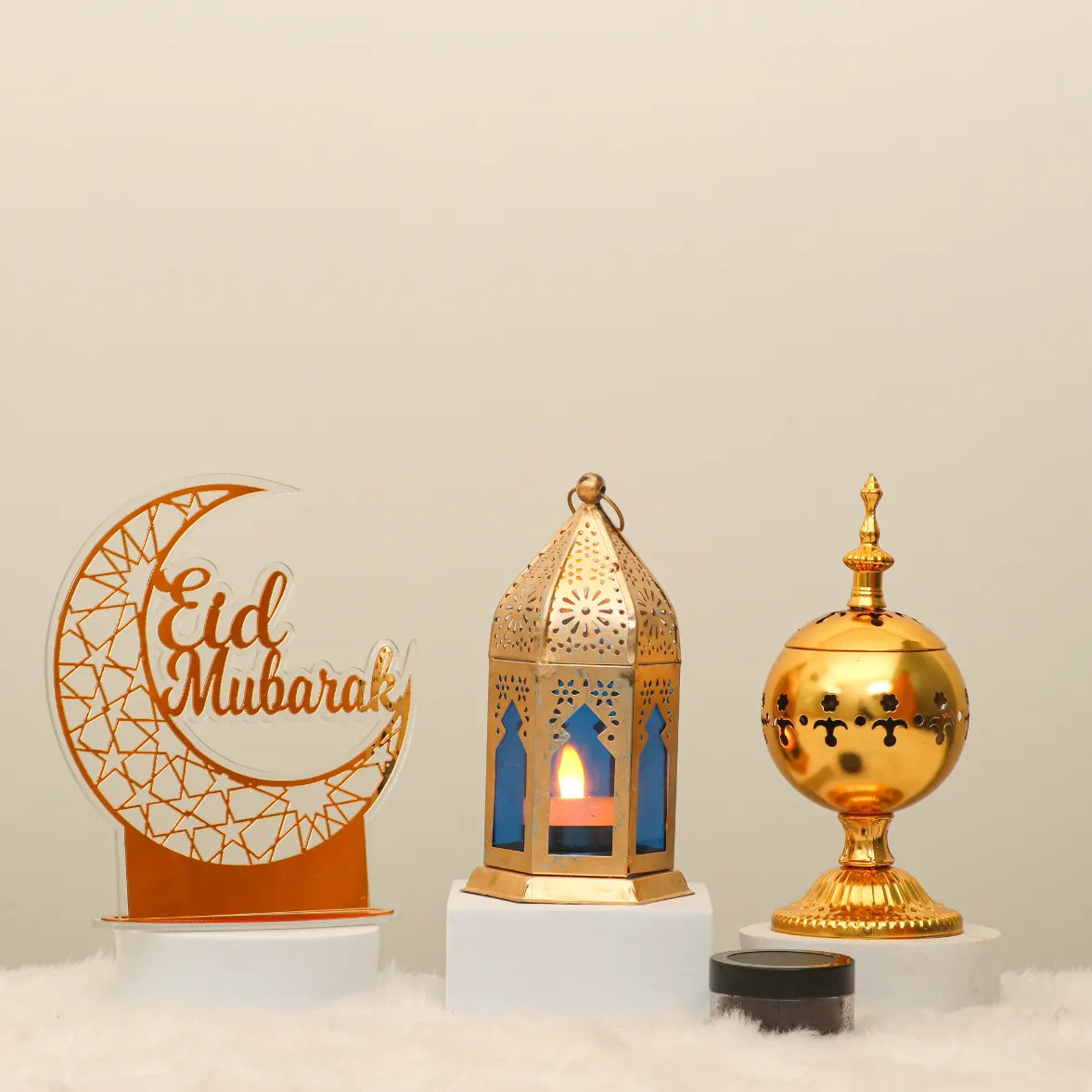 Noor Al-Eid Decor Set featuring a gold 'Eid Mubarak' crescent sign, ornate lantern with candlelight, and golden incense holder for festive home decor. Main image