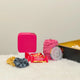 Contents of Shukr Eid Hamper displayed: pink jewelry box, hijab, almond caramel treats, scrunchies, and pinwheel, ideal Eid gift for women.